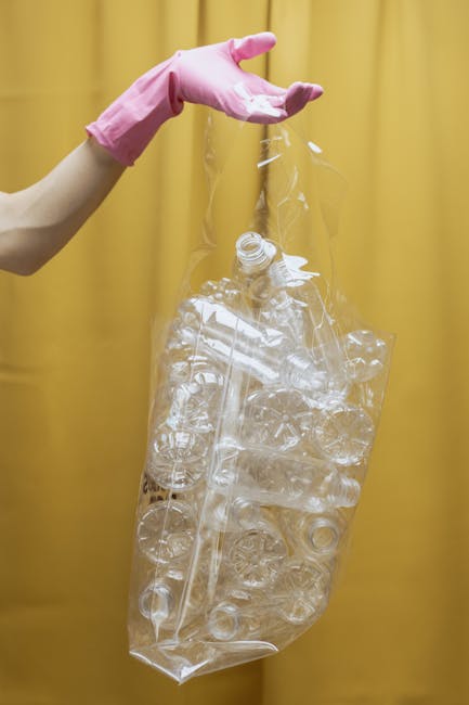 A person is seen disposing of brown paper bags filled with rubbish into a white bin that is designated for waste collection. The individual’s arm is extended, holding a paper bag over the open top o